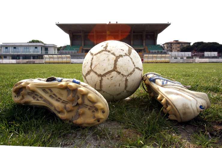 Primo piano di un pallone di un paio di scarpini da calcio