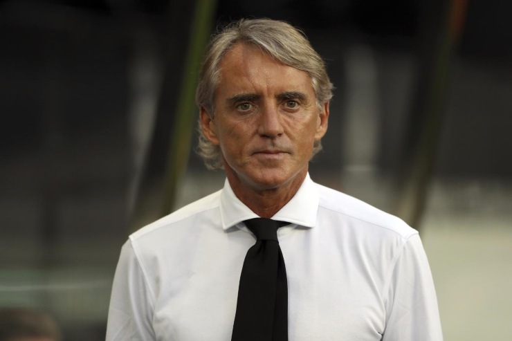 Roberto Mancini in primo piano e in camicia bianca e cravatta nera